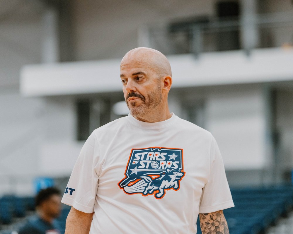 Jeff Calhoun, assistant coach, courtside in a Stars of Storrs tee