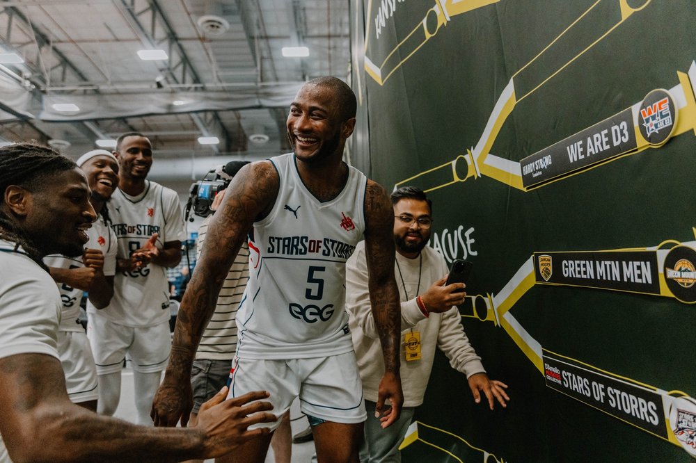 Rodney Purvis and teammates celebrating at the TBT bracket wall, Syracuse 2025